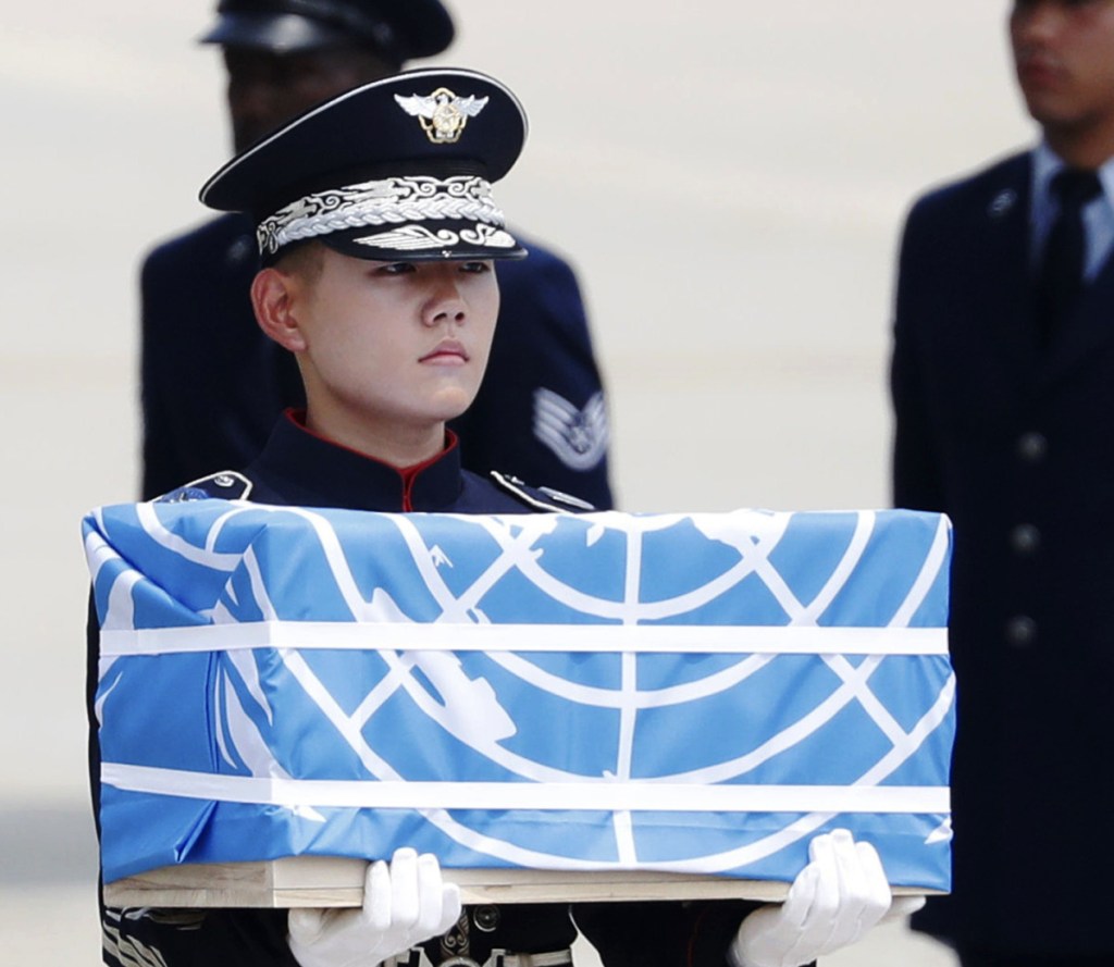 A soldier carries a box holding what North Korea says is the remains of a U.S. soldier killed in the Korean War.