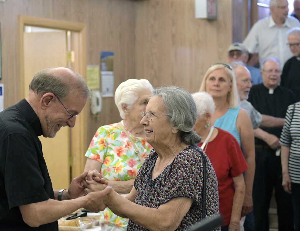 Hundreds crowd into the basement of St. Augustine's Church on Sunday in Augusta to wish the Rev. Francis Morin, or Father Frank, left, well in retirement. The former head of St. Michael Parish, which oversees a handful of Catholic churches in Augusta, Winthrop, Gardiner, Whitefield and Hallowell, is retiring after nine years in Augusta and a lifetime of priestly duties. He's known for reaching out to immigrants and others in need and other social justice efforts.