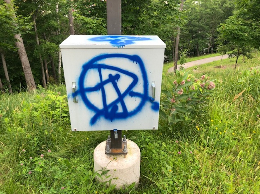 Graffiti on a utility box along the Debe Park River Trail in Skowhegan is one of several locations hit with spray paint sometime over the weekend. The trail ends at a Joyce Street house, where a man was shot in the head with a pellet gun on Sunday. Police are uncertain if the vandalism is connected to the shooting incident.