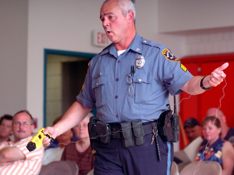 Dan Cook, seen in 2015 when he was a sergeant with the Winthrop Police Department, collects the coils of a Taser after discharging the weapon during a demonstration at a town council meeting. Cook has been serving as interim police chief for about a year and is retiring this month after a 25-year police career.