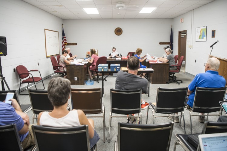 Volunteers count ballots Tuesday at the Winslow Town Office that were cast for the $8.1 million school bond, which voters passed 881-825 on June 12. Phil St. Onge, an opponent of the bond, said he is concerned that on 194 ballots the question was left blank and forced the recount as a way to inspect the ballots.