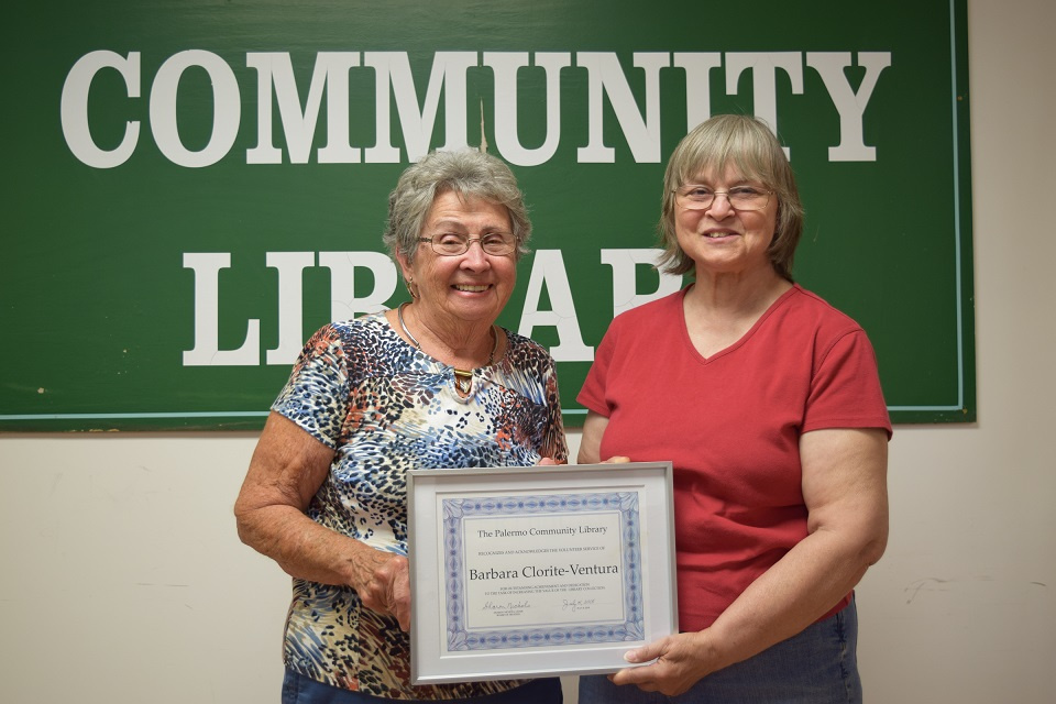 Palermo Community Library Board of Trustees Chair Sharon Nichols, left, recognizes Barbara Clorite-Ventura, a library volunteer, for her dedication in correcting the value of the Library's collection.