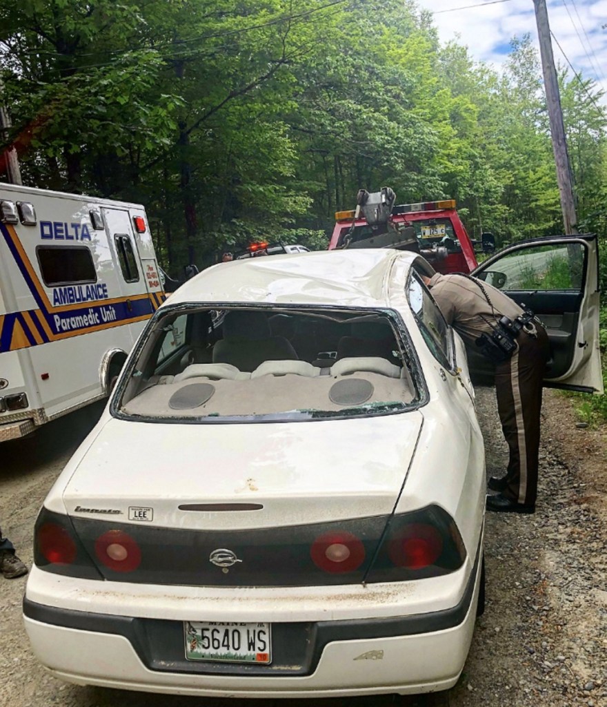 Cpl. Matt Cunningham, of the Somerset County Sheriff's Office, searches a Chevrolet Impala Thursday morning after a rollover accident on Wilder Hill Road in Smithfield. Kane Grondin, 17, who was driving the vehicle at the time of the crash, has been charged with imprudent speeding and carrying passengers with an intermediate license.