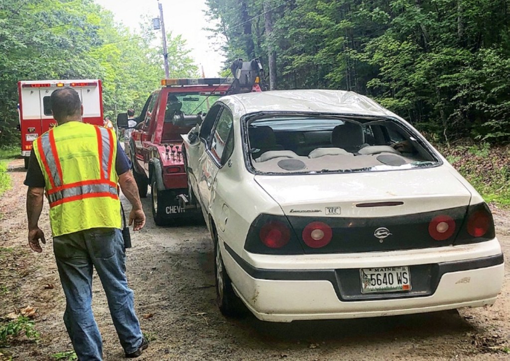 Smithfield Fire Chief Jack Easler stands next to a Chevrolet Impala on Thursday morning that was involved in a rollover accident on Wilder Hill Road in Smithfield. Police think the crash was caused by the driver traveling at an excessive rate of speed.