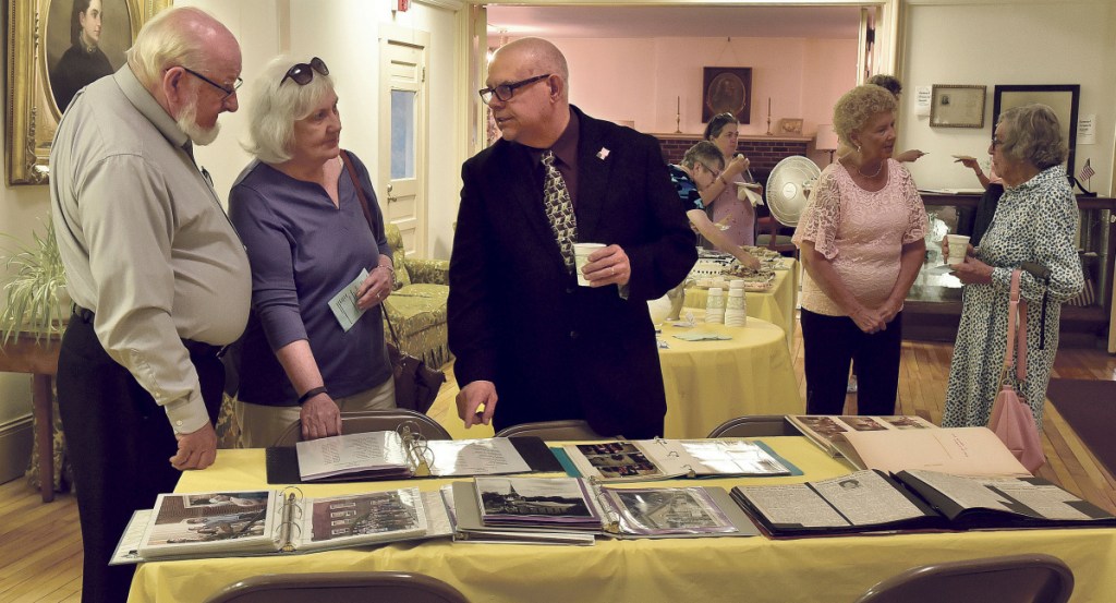First Baptist Church pastor Russell LaFlamme, right, shows some historical photos of the church to Pastor Ronald Morrell of China Baptist Church and his wife, Linda, during the 200th anniversary celebration on Sunday.