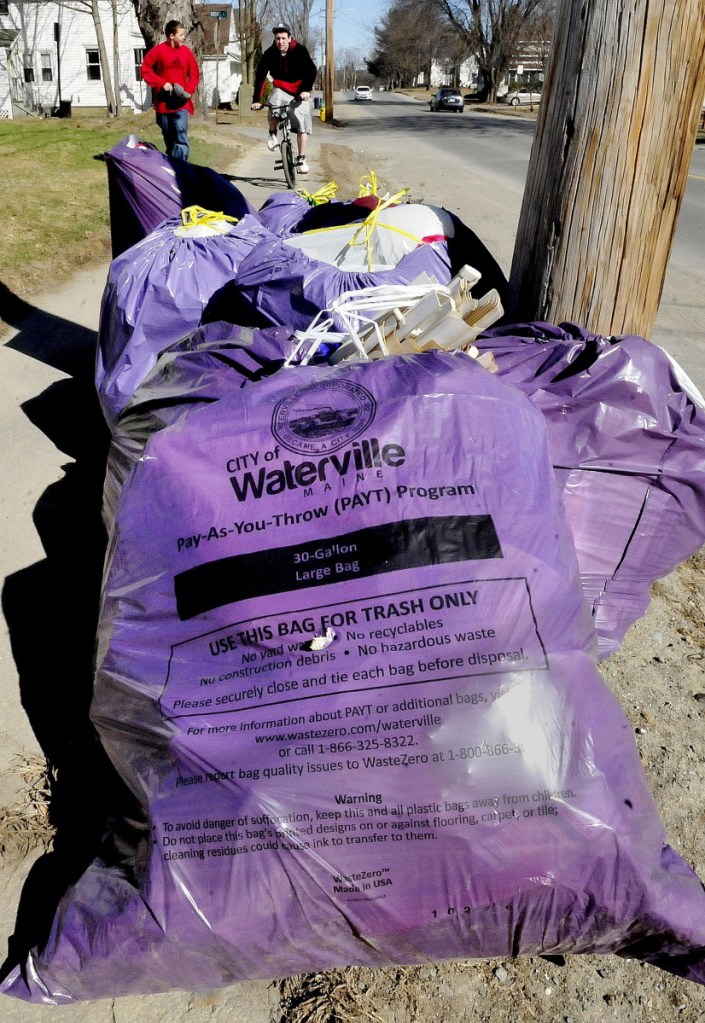 Purple bags of trash used in the pay-as-you-throw trash program in Waterville sit curbside for pick up on Western Avenue on April 15, 2015. The City Council will consider extending an agreement with the bag supplier for another two years.