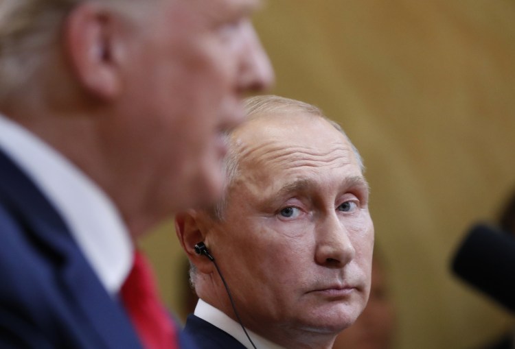 Russian President Vladimir Putin listens to U.S. President Donald Trump during a news conference Monday after the meeting in Helsinki, Finland. Trump tried to walk back some of his comments Tuesday.