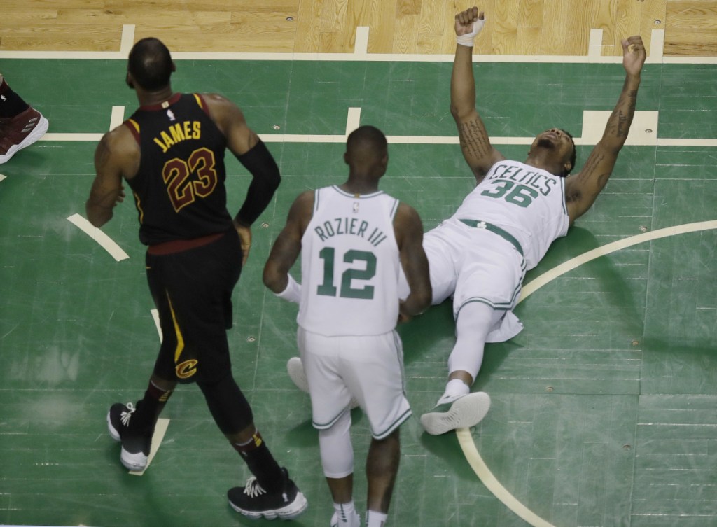 In this May 27 photo, Boston Celtics guard Marcus Smart (36) reacts after drawing an offensive foul by Cleveland Cavaliers forward LeBron James (23) during the first half in Game 7 of the Eastern Conference finals, in Boston. A person with knowledge of the agreement tells The Associated Press that Smart signed a four-year, $52 million contract with the Celtics.