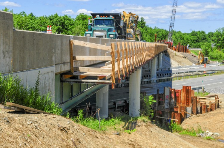Wyman and Simpson employees work on re-decking an overpass that carries southbound traffic from Interstate 95's Exit 103 over the highway to the Interstate 295 toll booth on Wednesday in West Gardiner.