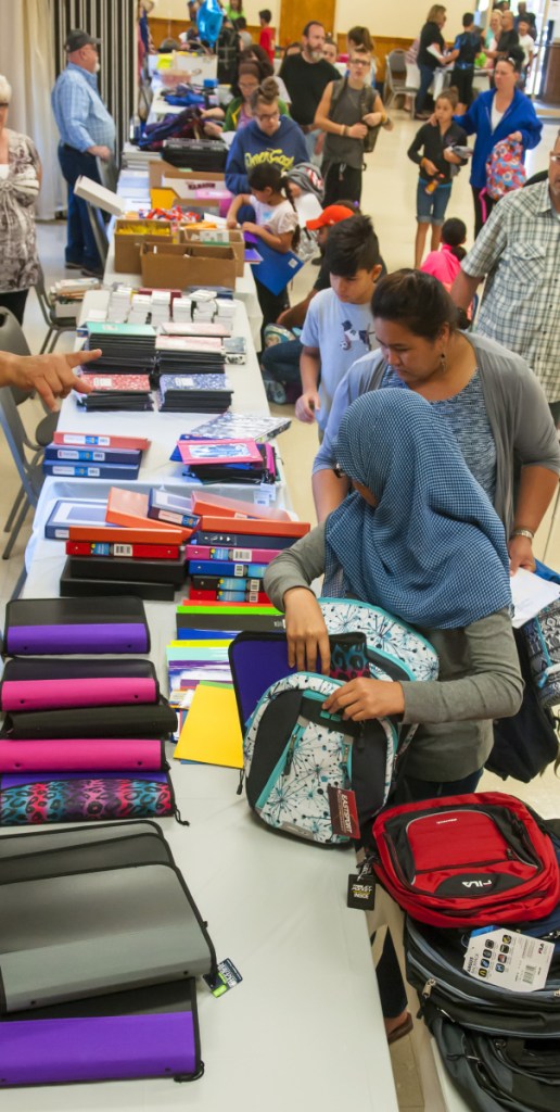 People pick up backpacks and school supplies Aug. 26, 2017, during a giveaway at the Augusta Elks Lodge.