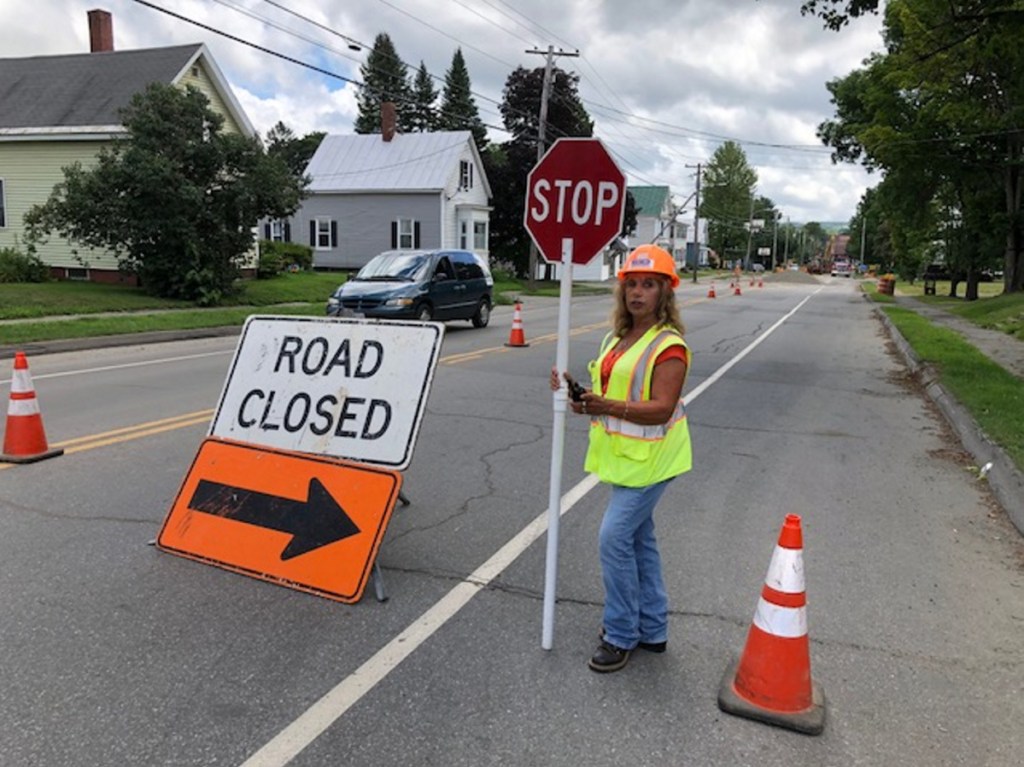 Susan Dorval, of Oakland, works Wednesday diverting traffic on North Avenue in Skowhegan during construction of a combined sewer overflow project, which fell behind schedule last year and is due to be completed in September.