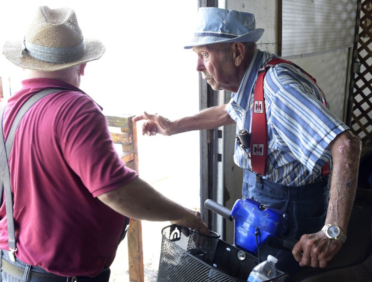 Paul Fox, right, and Pat Smith arrange parking for vendors and displays on Tuesday at the Monmouth Fair. The longtime volunteers help ensure space is allotted for every food cart and exhibition at the annual fair, which opens Wednesday.
