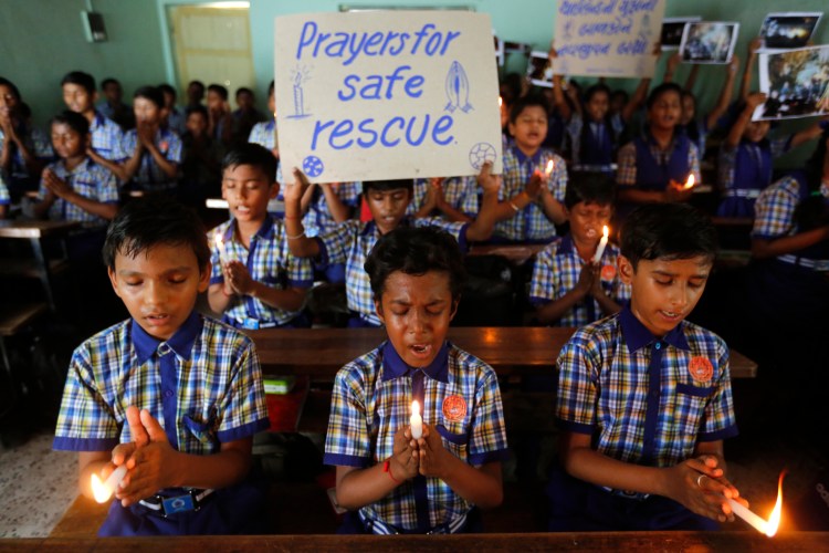 Indian students hold candles and pray Monday for boys and their soccer coach who have been trapped since June 23, in Mae Sai, Chiang Rai province, northern Thailand, at a school in Ahmadabad, India.