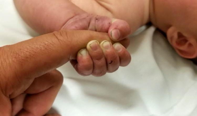 A 5-month-old boy with dirt under his fingernails is seen Sunday after authorities say the baby survived about nine hours being buried under sticks and debris in the woods in Montana.
