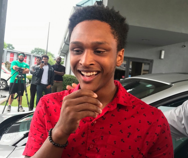Alabama college student Walter Carr reacts after being given a new car by Bellhops CEO Luke Marklin in Pelham, Ala., on Monday. Carr's vehicle broke down just before his first day of work, so he made the 20-mile journey on foot, a feat that earned him fame — and a new car.