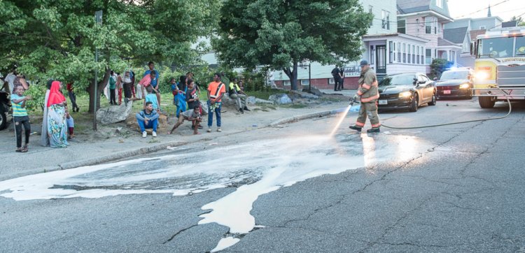 A Lewiston firefighter hoses down blood stains Monday evening on Blake Street near Maple Street after a man was assaulted and taken to a hospital. Police had a good description of the suspect and were searching for him late Monday. 