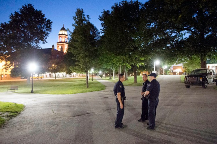 Lt. Mark Cornelio, left, officer Charlie Weaver and officer Jeremy Somma of the Lewiston Police Department keep an eye Wednesday night on Kennedy Park in downtown Lewiston. 