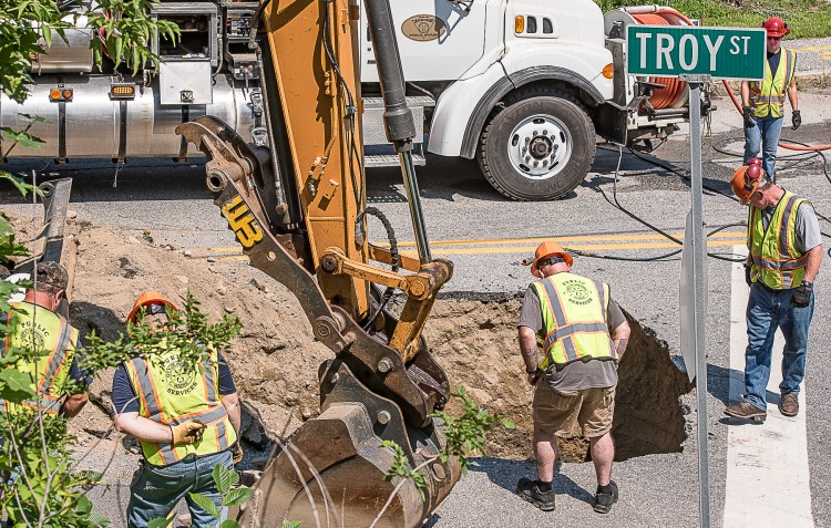 Auburn Public Works employees examine a large sinkhole at the end of Troy Street in Auburn on Friday, July 27, 2018. A sudden downpour Thursday afternoon caused extensive flooding in the city.