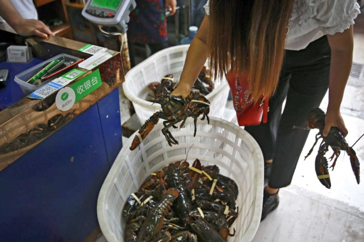 A dealer buys imported lobsters from a wholesaler at the Jingshen seafood market in Beijing.