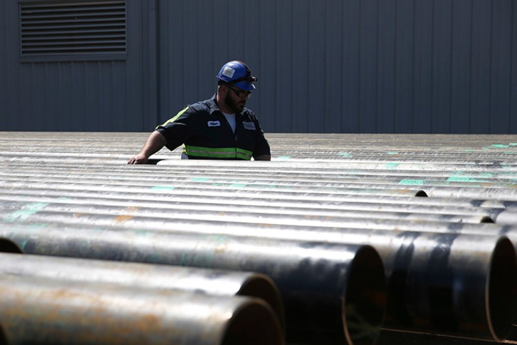 William Hampton walks between steel pipes at the Borusan Mannesmann plant in Texas in April. Borusan said the Baytown production line would no longer be competitive and "jobs would be threatened" if it cannot import 135,000 metric tons of steel annually over the next two years. The pipes Borusan produces are used primarily as casing for oil and natural gas wells.