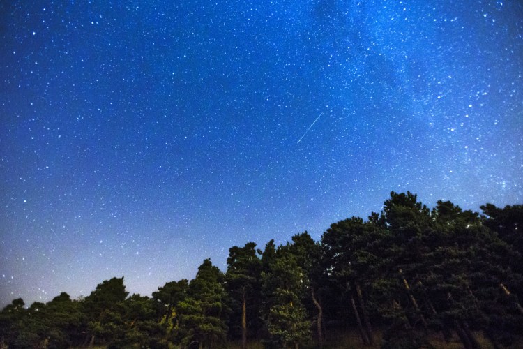 Two meteors, center and lower left, streak across the sky during the annual Perseid meteor shower in 2014. 