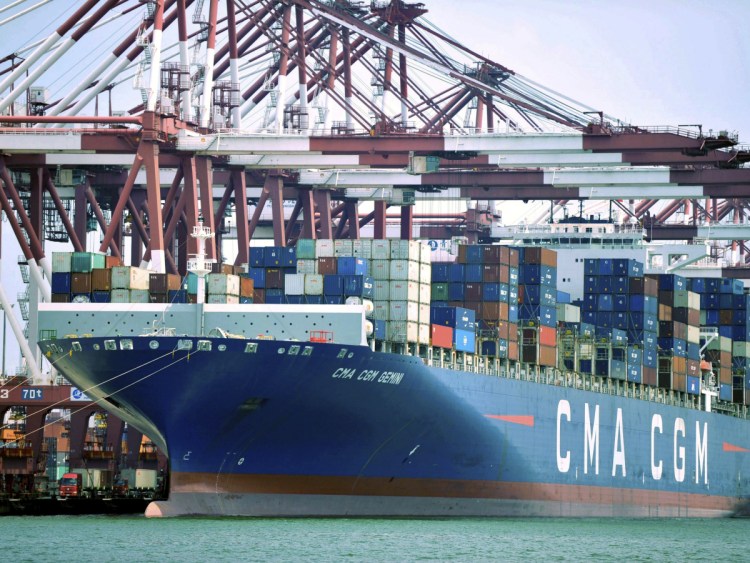 A container ship is docked at a port in Qingdao, in China's Shandong Province. Further roiling the trade debate is the falling value of China's currency, which makes its exports cheaper around the world. It's unclear if the Chinese government is manipulating its currency.