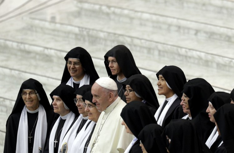 Pope Francis poses with nuns at the Vatican on Wednesday. Advocates say expanding the ministry would give women a greater role, while also helping address effects of the priest shortage in some parts of the world.