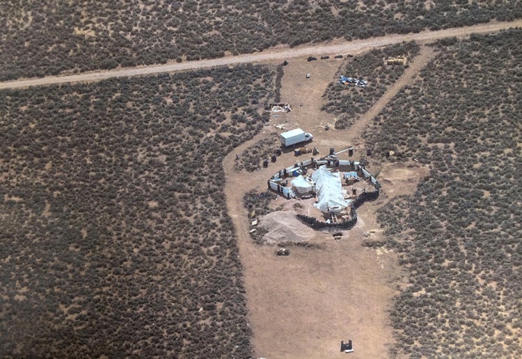 Aerial photo released by the Taos County Sheriff's Office shows a rural compound during an unsuccessful search for a missing 3-year-old boy in Amalia, N.M. Law enforcement officers searching the compound for the missing child found 11 other children in filthy conditions.