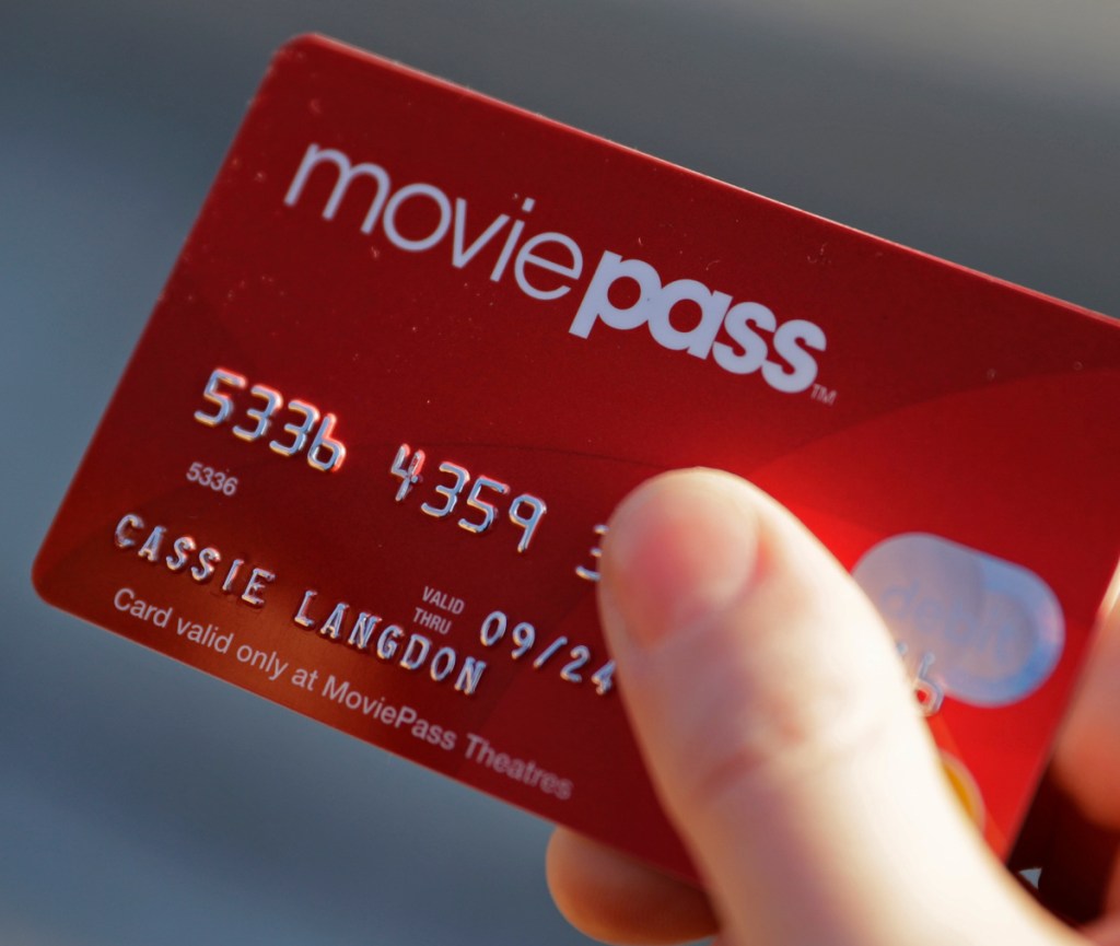 FILE - In this Jan. 30, 2018, file photo, Cassie Langdon holds her MoviePass card outside AMC Indianapolis 17 theatre in Indianapolis. MoviePass, the discount service for movie tickets, is raising prices by 50 percent and barring viewings of most major releases during the first two weeks. (Associated Press)