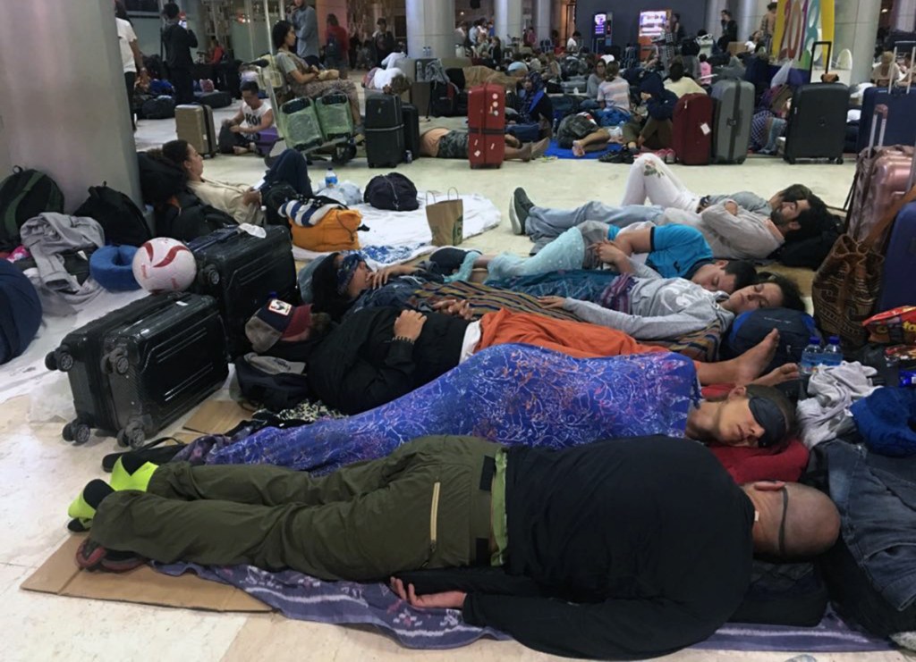 Foreign tourists sleep on the floor as they are stranded at Lombok International Airport following an earthquake in Praya, Lombok Island, Indonesia, Monday, Aug. 6, 2018. The powerful earthquake flattened houses and toppled bridges on the Indonesian tourist island of Lombok, killing a large number of people and shaking neighboring Bali, as authorities said that rescuers still hadn't reached some devastated areas and the death toll would climb. (AP Photo/Niniek Karmini)