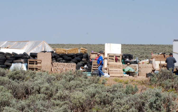 Officials survey the  compound at Amalia, N.M., on Tuesday.