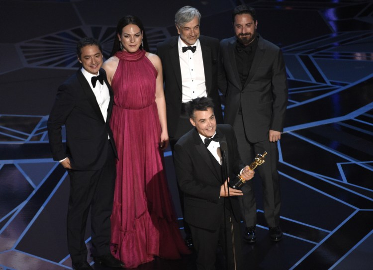 FILE - In this March 4, 2018 file photo, Sebastian Lelio, foreground center, and Juan de Dios Larrain, background from left, transgender actress Daniela Vega, Francisco Reyes, and Pablo Larrain accept the award for best foreign language film for "A Fantastic Woman" at the Oscars in Los Angeles. 