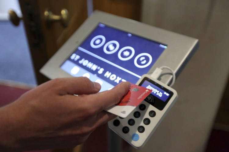This card reader allows churchgoers to donate money at St. John's in London. Preset sums range from $6.50 to $65.50.