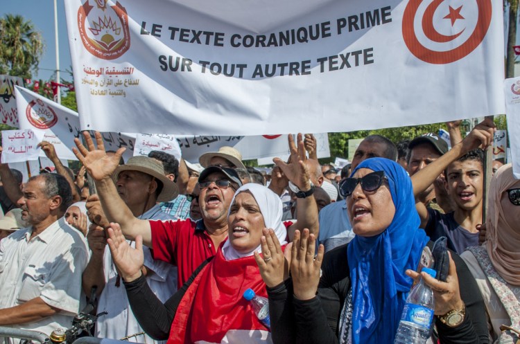 People demonstrate with a banner reading "Quran text before any other text" outside the Tunisian capital of Tunis on Saturday. 