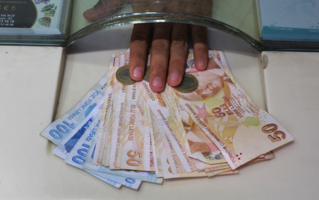 A vendor exchanges foreign currency with Turkish liras at a currency exchange shop in Istanbul, Monday, Aug. 13, 2018. Turkey's central bank announced a series of measures on Monday to free up cash for banks as the country grapples with a currency crisis. The Turkish lira has nosedived over the past week and tumbled another 7 percent on Monday as the central bank's measures failed to restore investor confidence. (AP Photo/Mucahid Yapici)