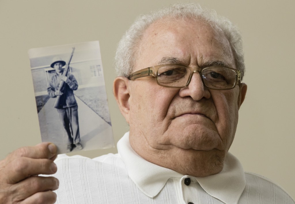 Dominic Ragucci poses for a portrait in Philadelphia with a photo of his brother, Emil, who was killed in action on the Central Pacific island of Tarawa during World War II.