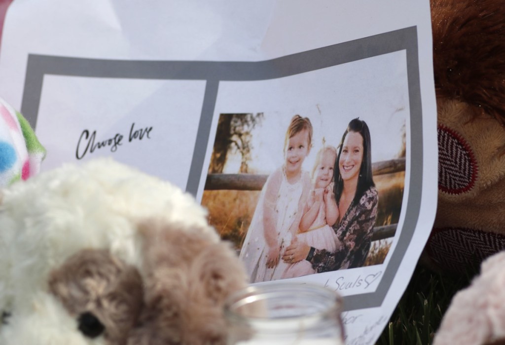 A photograph sits amid tributes as they grow outside the home where a pregnant woman, Shanann Watts, and her two daughters, Bella and Celeste, lived Thursday in Frederick, Colo.