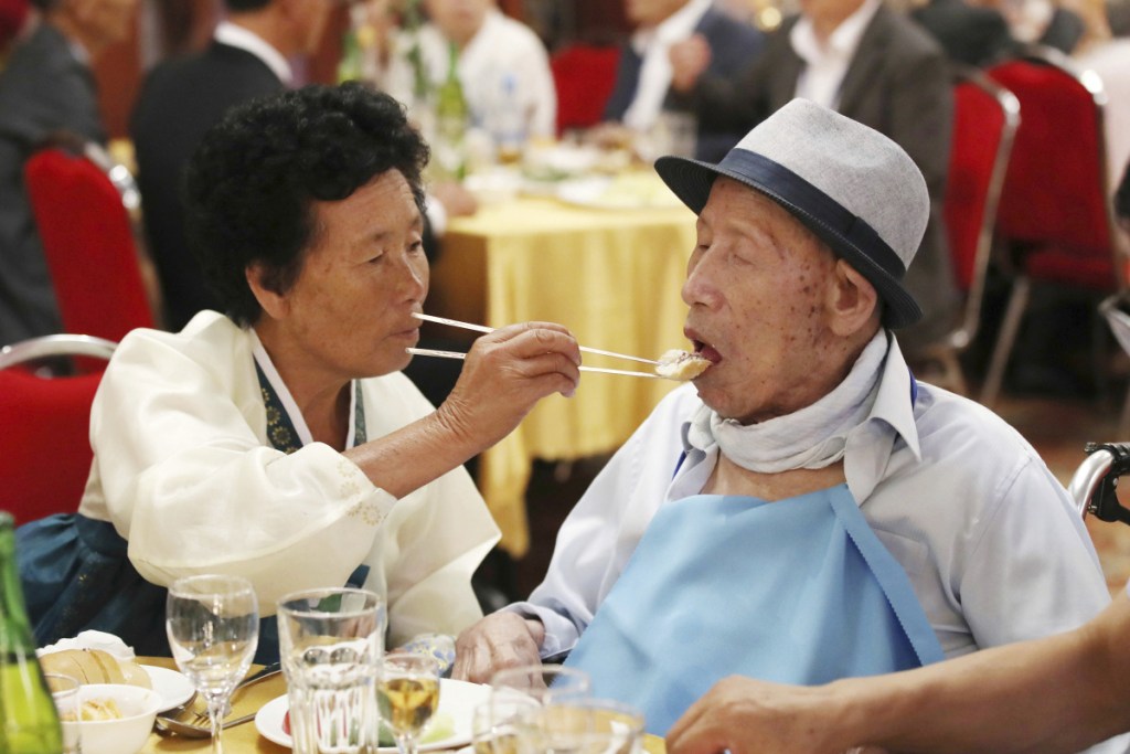 North Korean Ahn Jong Sun, 70, left, feeds her South Korean father Ahn Jong-ho, 100, during a dinner at the Diamond Mountain resort in North Korea on Monday. Dozens of elderly South Koreans crossed the heavily fortified border into North Korea on Monday for heart-wrenching meetings with relatives most haven't seen since they were separated by the turmoil of the Korean War.