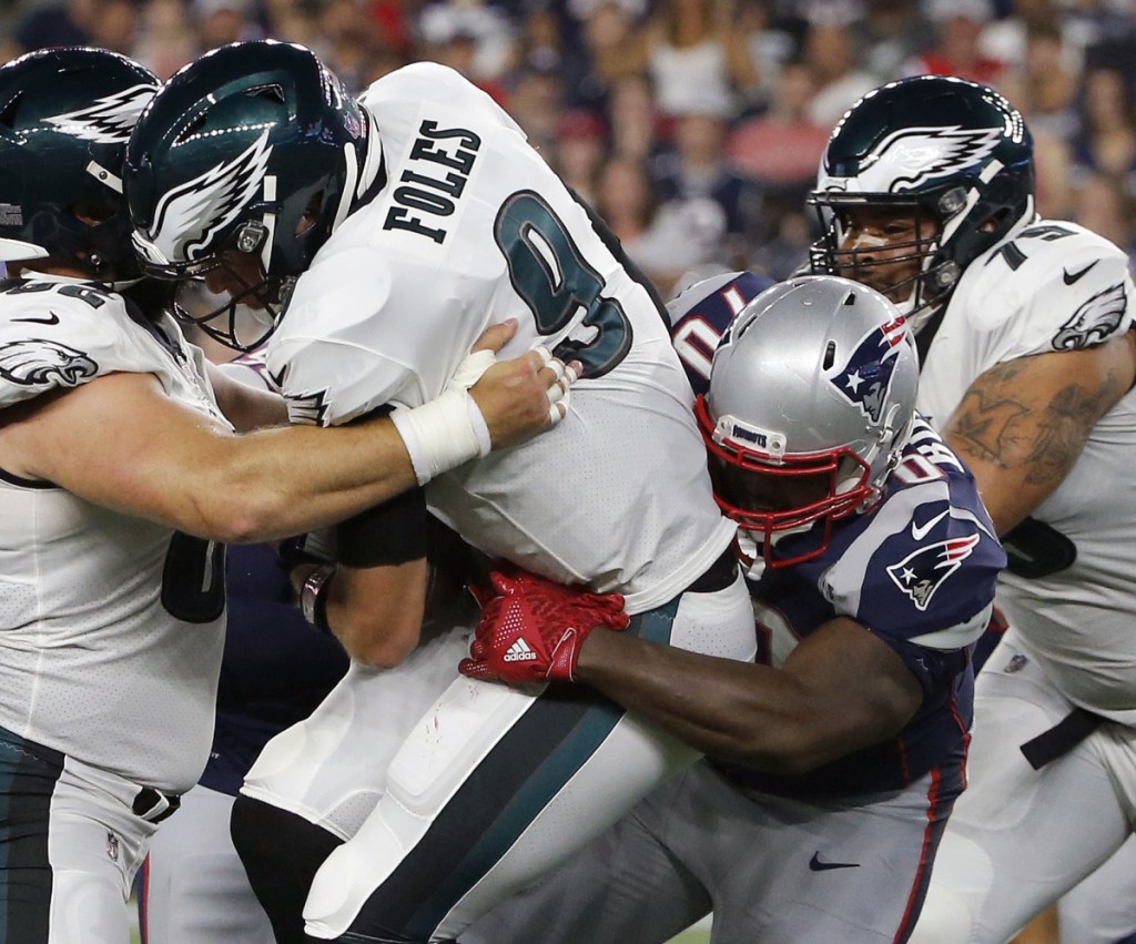 New England Patriots defensive tackle Adam Butler, right, sacks Philadelphia Eagles quarterback Nick Foles during the first half of a preseason NFL football game, Thursday, Aug. 16, 2018, in Foxborough, Mass. (AP Photo/Mary Schwalm)
