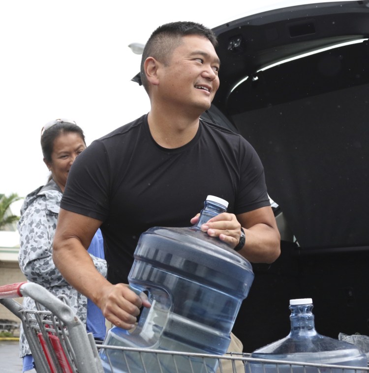 Loren Aquino of Honolulu loads water into his car on Wednesday. 