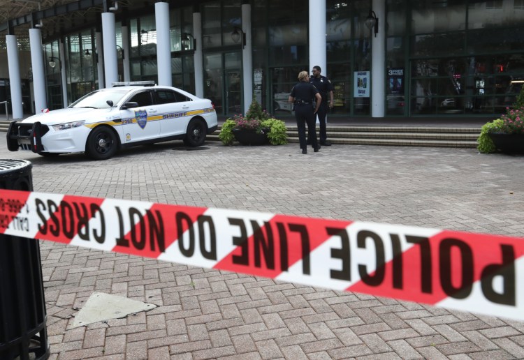 Jacksonville police officers guard an area near the scene of a fatal shooting at The Jacksonville Landing in Jacksonville, Fla. A gunman opened fire at a video game tournament killing multiple people and then fatally shooting himself in a rampage that wounded several others.