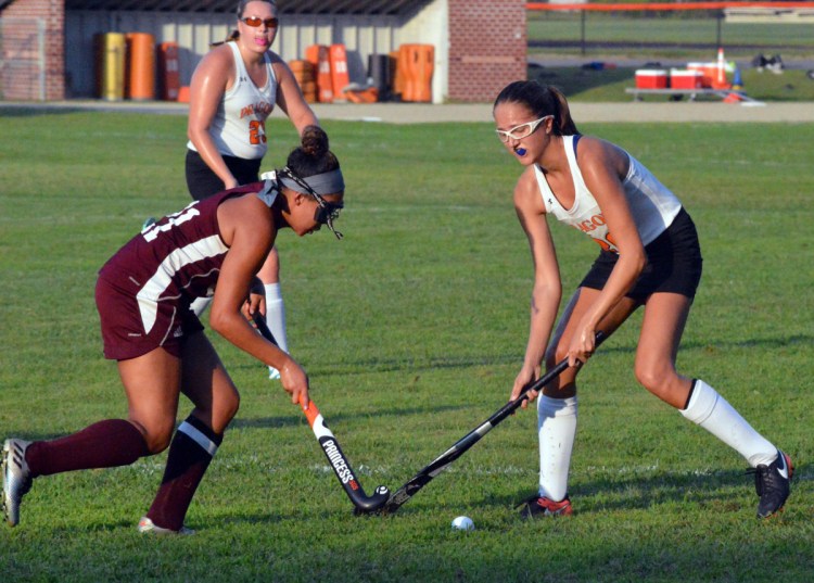 Kiara Fournier, left, of Edward Little battles for a loose ball with Brunswick's Erin Coughlin during their KVAC field hockey season opener Wednesday in Brunswick. Fournier was one of five goal scorers for the Red Eddies in a 5-0 victory.