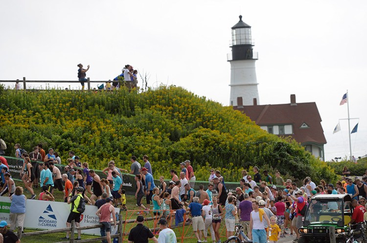 Spectators watch as runners finish the Beach to Beacon near Portland Head Light at Ft. Williams.