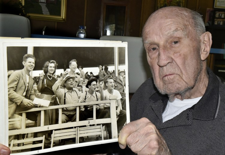 Donald Eames, 91, of Norridgewock, holds a black-and-white photograph Tuesday that shows him cheering during a horse race in the mid-1930s at the Skowhegan Fairgrounds. Eames, who has volunteered for 80 years at the fair, is at bottom right in photo.