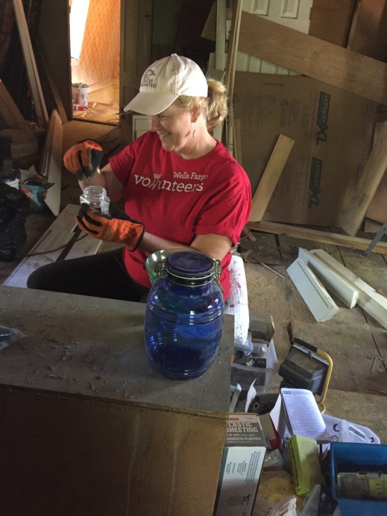 Katy Wood, a strategy consultant from Wells Fargo Community Banking, helps clean up the third floor of the Betsy Ann Ross House of Hope on July 19 in Augusta .