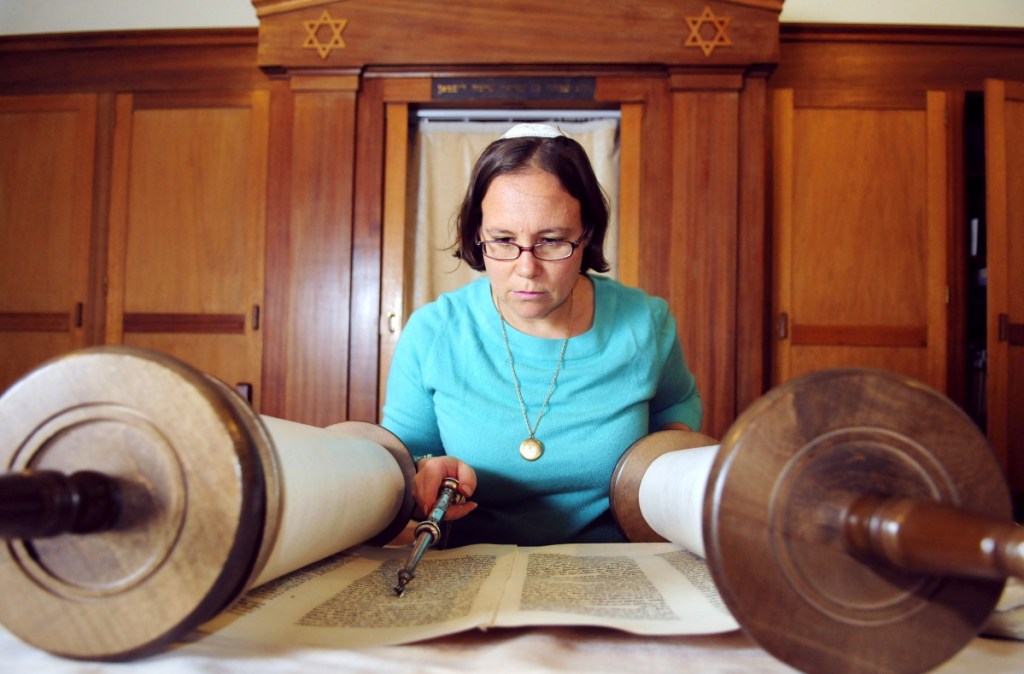 Rabbi Erica Asch checks her position in the text as she rolls a Torah scroll in September 2014 in preparation for Rosh Hashanah services at Temple Beth El in Augusta. She is leading a local group seeking Augusta to add major religious holidays for multiple religions, including Jewish and Muslim holidays, to school calendars. The Augusta Board of Education's Policy Committee will discuss the proposal Monday.