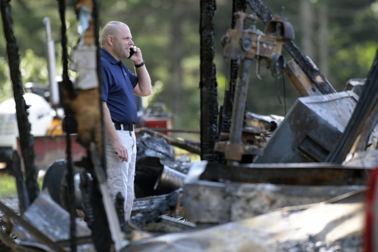 A investigator with the Office of State Fire Marshal on Wednesday examines a residence destroyed by fire on Hunts Meadow Road in Whitefield.