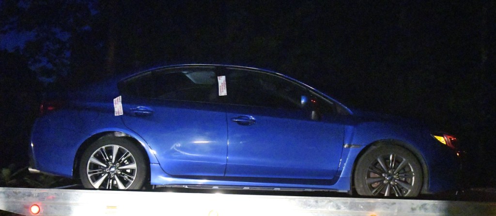 A car, operated by a man who committed suicide after being police conducted a traffic stop, is towed away Thursday night from Timberwood Drive in Gardiner. A body was discovered in the trunk of the car, a blue Sabaru with Massachusetts license plates, police said.