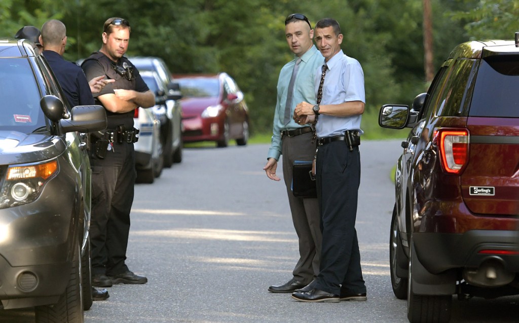 Maine State Police Col. John Cote, right, speaks with officers Thursday evening at an incident involving two deaths on Timberwood Drive in Gardiner.