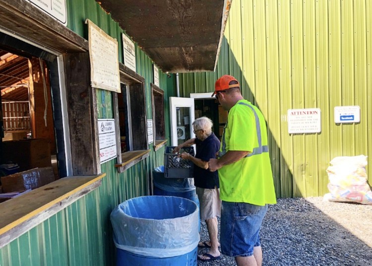 Unity Area Recycling Center manager Stanley Besancon helps Betty Gross, a part-time Unity resident, sort her recyclable material Friday morning in Thorndike. The center recently stopped accepting most plastic material, citing the drop in demand in the Chinese market.